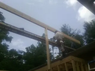 Carpenter setting a ridge beam over a new addition frame — Ice Dam Removal by Roofing Brothers in Table Grove