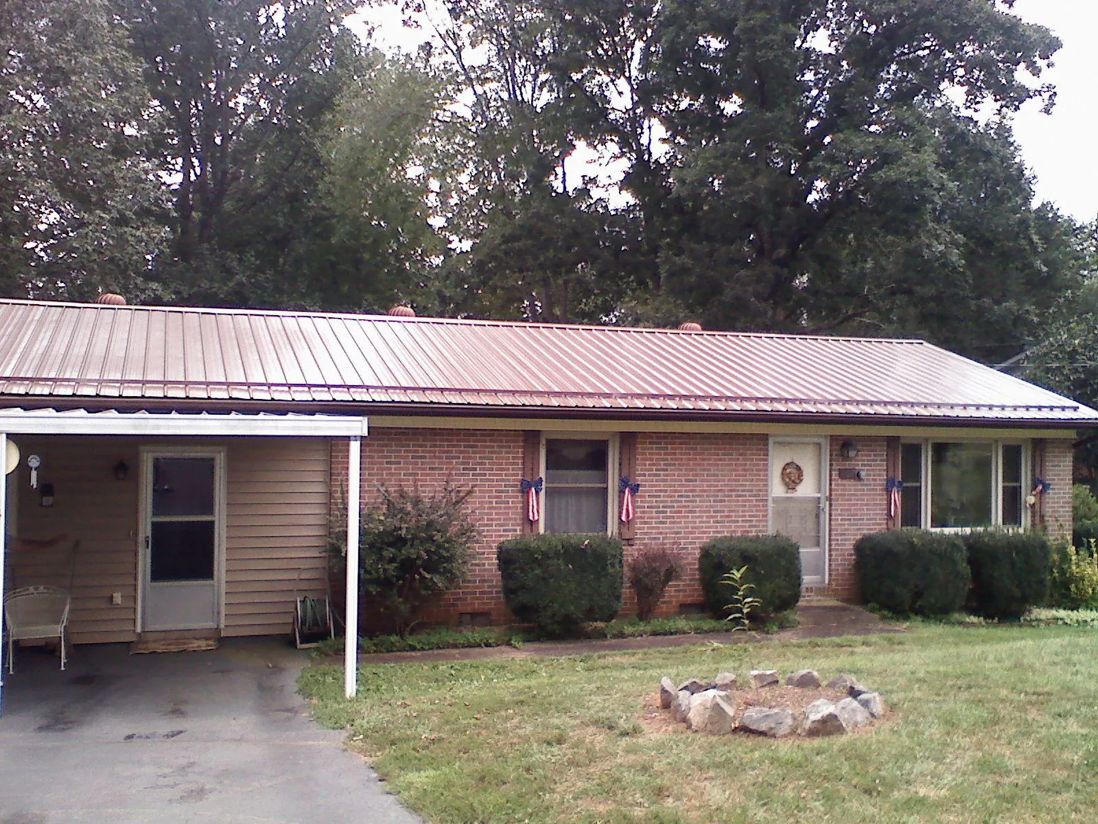 Bronze metal roof and carport on a brick ranch home — Roof Repair work by our crew in Table Grove