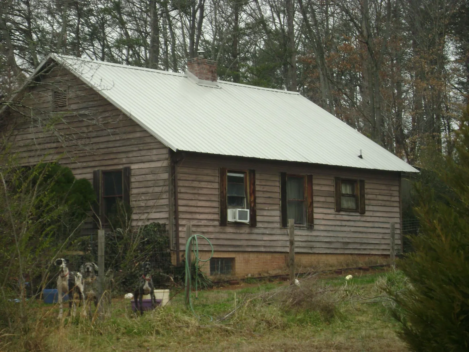 White metal roof on an old wood sided farmhouse, from a Metal Roof Installation job in Table Grove